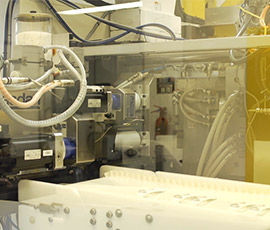 Medical device manufacturing process: close-up of precision injection molding machine producing components. Team Consulting's expertise in medical technology design and development ensures high-quality results.
