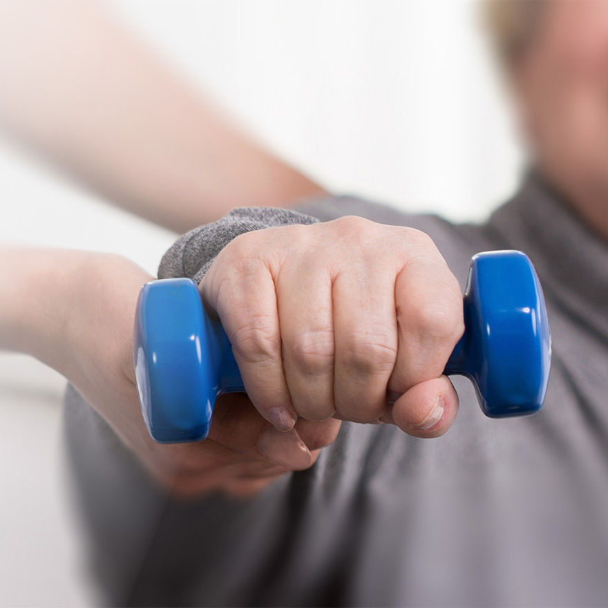 Hand holding blue weight during rehabilitation