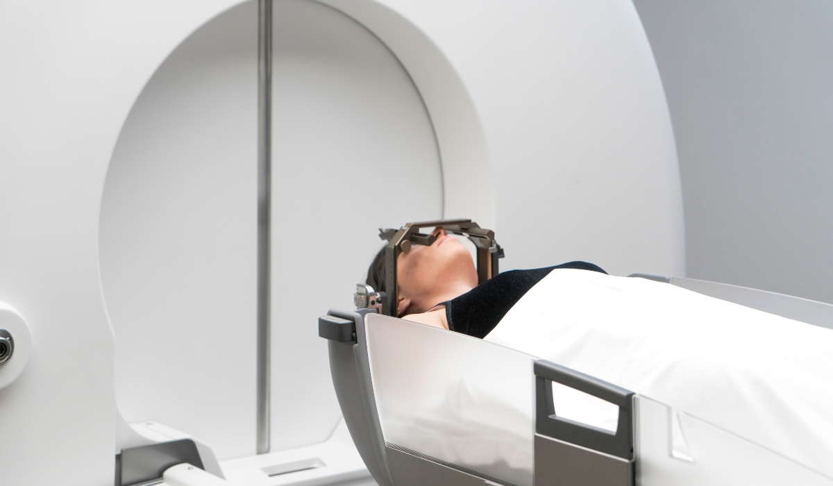 The patient lies in front of the device for the treatment of cancer with a gamma knife. She has a metal clip cap on