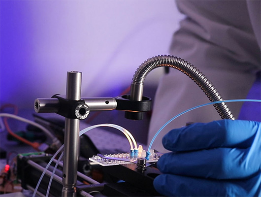 Gloved hands interacting with cell sorting prototype rig