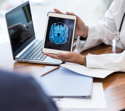 doctor using software to show MRI scan on a tablet